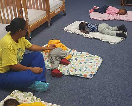 teacher sitting with infants